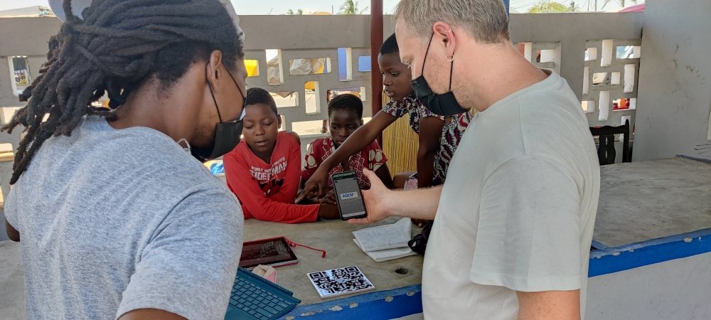 Hamilton Roce Jordão (left) and Michel Becks demonstrate the QR code to local children