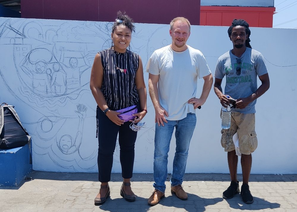 Artist Hamilton Roce Jordão (right) at his mural in Mozambique