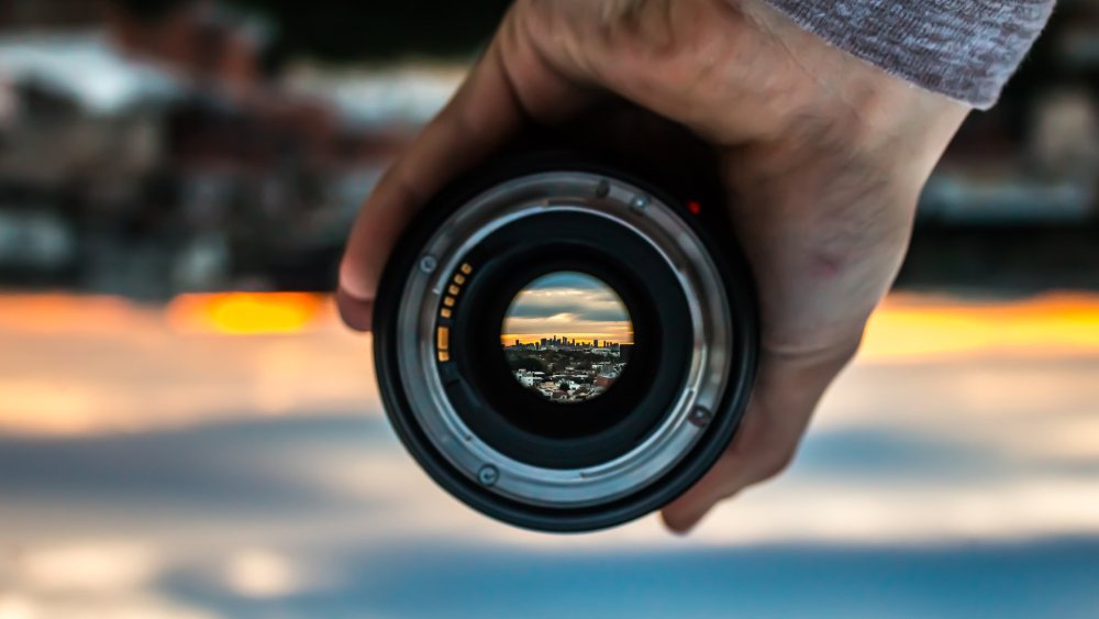 Photo of person's hand holding camera lens