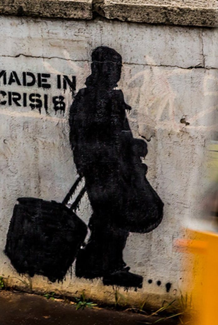Photo of a wall with graffiti that reads "made in crisis".