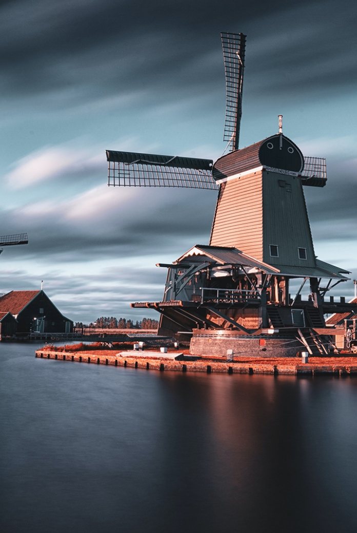 Photo of Dutch windmills next to a lake.