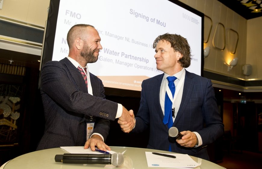 NWP acting director Ewout van Galen and Aart Mulder of FMO Development Bank shake hands on the renewal of the MoU at the AIWW Summit 2018