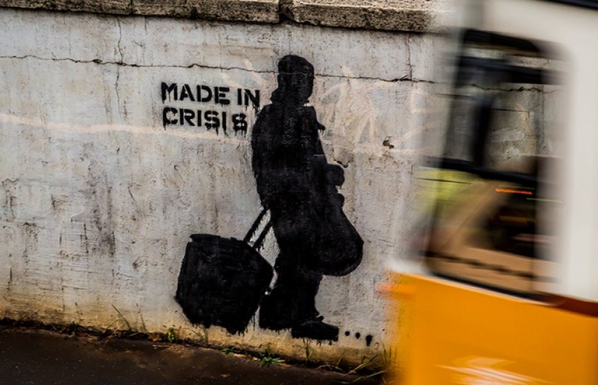 Photo of a wall with graffiti that reads "made in crisis".