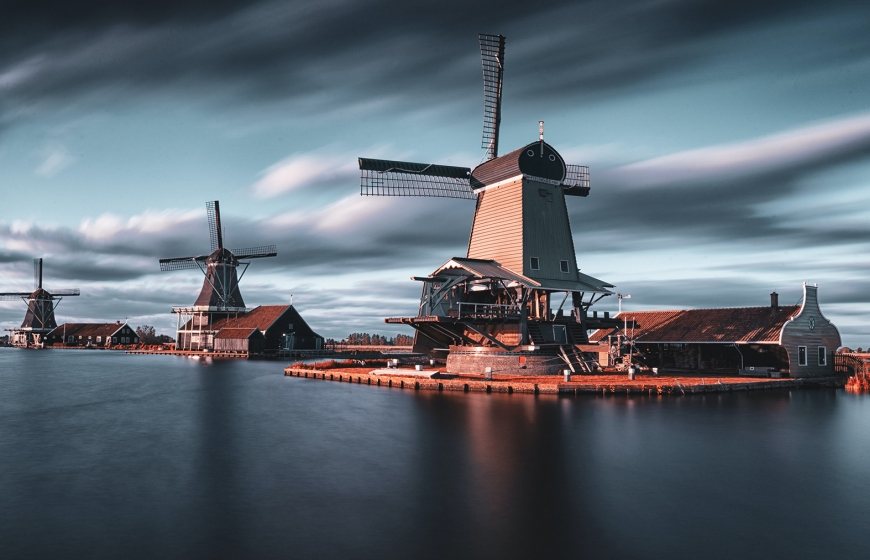 Photo of Dutch windmills next to a lake.
