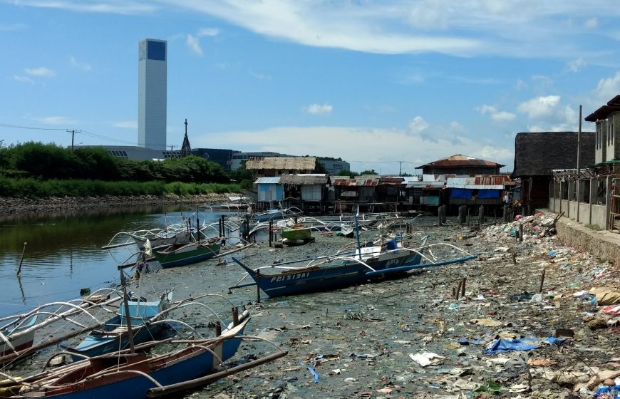 Riverside in Philippines, with boats and pollution