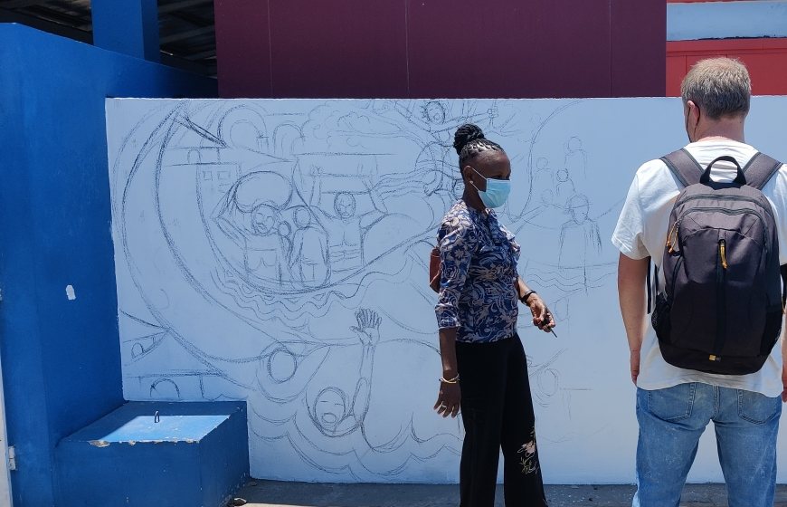 Artist Hamilton Roce Jordão and onlookers at his mural in Mozambique