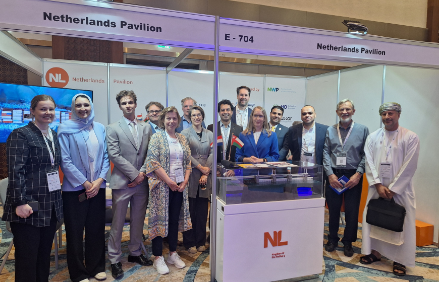 A group of people that is visiting Oman Water Week standing at the Netherlands Pavilion booth in april 2025