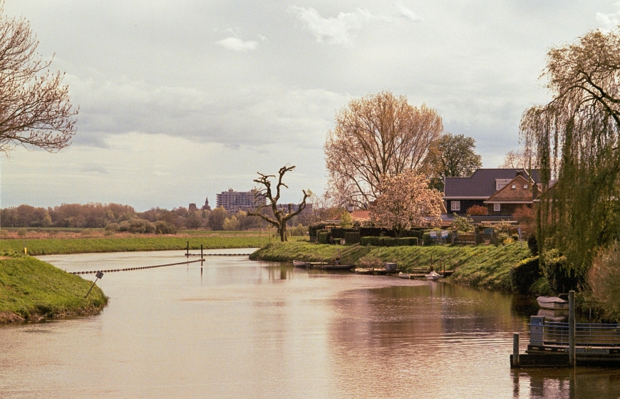 River meandering through Dutch landscape with meadows and houses