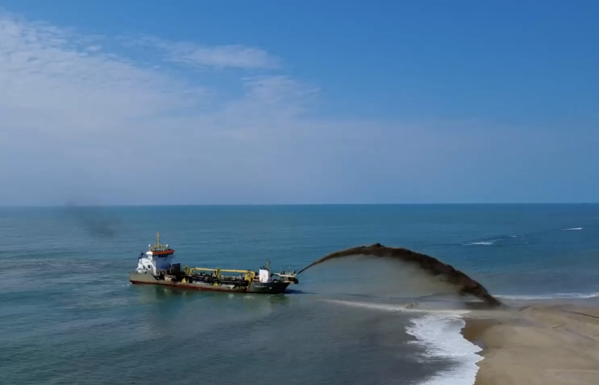 Coastal restoration: a dredging ship spraying sand onto the shoreline to combat beach erosion. Credits: RVO