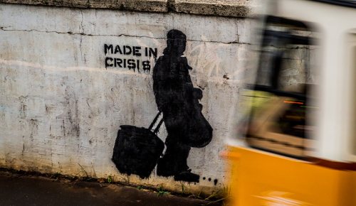 Photo of a wall with graffiti that reads "made in crisis".