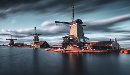 Photo of Dutch windmills next to a lake.