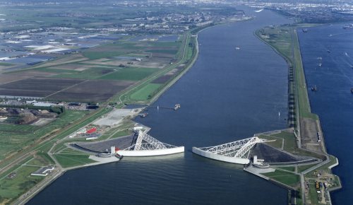 Aerial vies of Nieuwe Waterweg river with Maeslant storm surge barrier almost closed