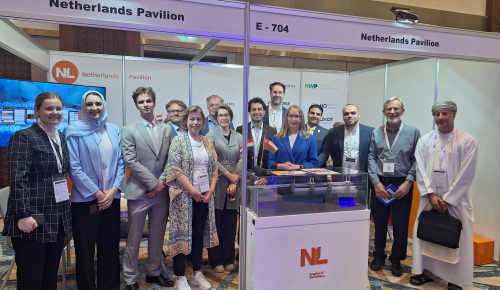 A group of people that is visiting Oman Water Week standing at the Netherlands Pavilion booth in april 2025